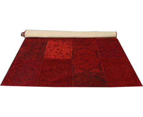 A red ground wool patch work rug 228cm x 154cm.