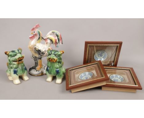 A pair of Chinese ceramic dogs of fo, three framed display tea bowls and a model of a cockerel.