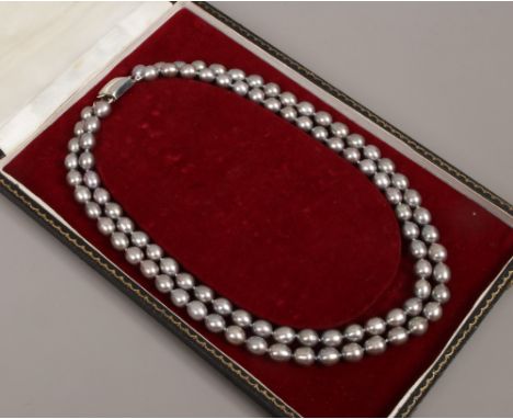 A cased double row grey pearl necklace.