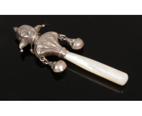 A silver and mother of pearl babies rattle formed as a jester stamped 925.