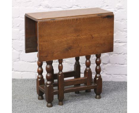 A small oak gateleg table raised on bobbin turned supports.