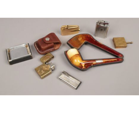 A cased white metal mounted meerschaum pipe along with a collection of lighters to include a cased Zippo lighter etc.