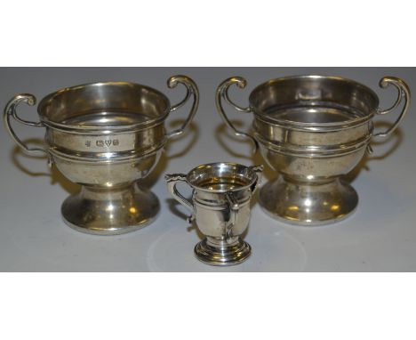 A pair of George V silver miniature trophy cups, Chester 1915; a miniature tyg, Birmingham 1907