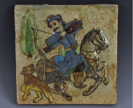 A Qajar fritware square tile, the centre moulded in high relief and and decorated in underglaze, coloured pigments with a hor