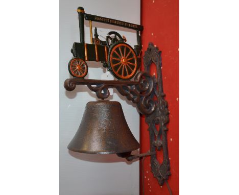 A reproduction cast metal wall mounted bell with traction engine pediment.