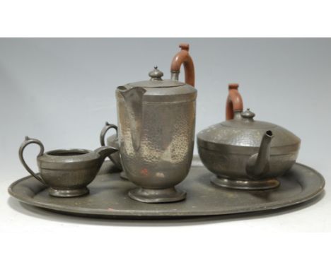 An early 20th century hammered pewter four piece tea and coffee service on oval tray, with presentation inscription 