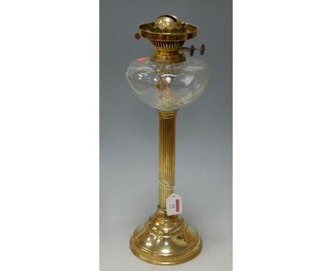 An early 20th century brass pedestal oil lamp with clear glass reservoir