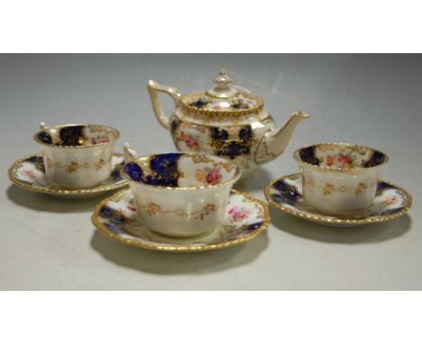 A Coalport porcelain part tea service decorated with sprays of flowers and cobalt blue panels on a white ground and heightene