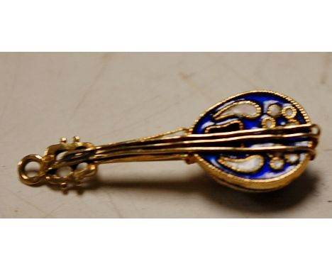 A yellow metal and enamel set pendant in the form of a cello, 2.7g, 3cm