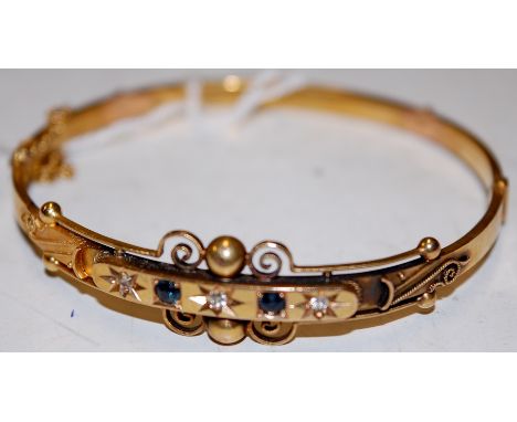 A George V 15ct yellow gold sapphire and diamond set hinged bangle with safety chain, 8.6g, Chester 1913, dia.6.3cm  Conditio