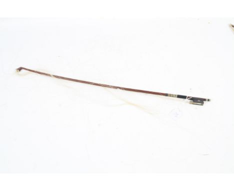 A German nickel mounted violin bow by W Seifert. The stick octagonal, the ebony frog inlaid with pearl eyes and the ebony adj