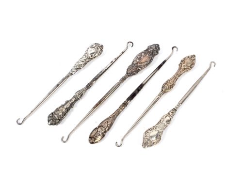 A collection of six late 19th century silver handled button hooks. Each with steel hook, five cast with rocaille handles, one