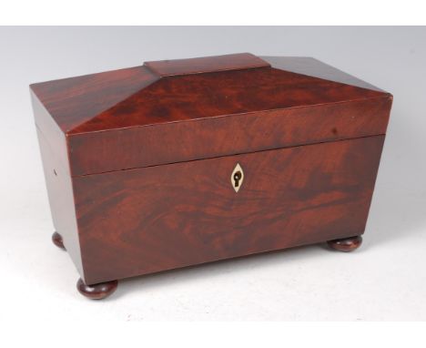 A circa 1830 mahogany tea caddy, of sarcophagus form, having fitted interior of two hinged caddies flanking glass mixing bowl