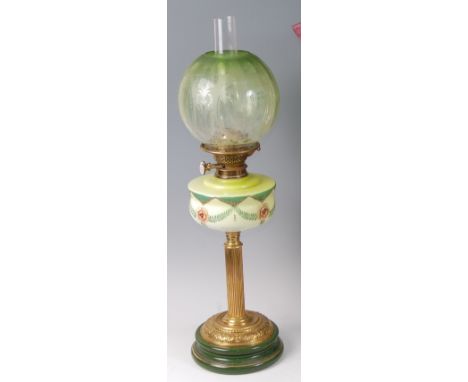 A late Victorian brass and green glass pedestal oil lamp, having green tinted and acid etched floral decorated shade, over po