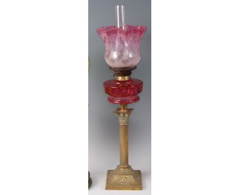 A late Victorian brass Corinthian column oil lamp, having pink tinted acid etched handkerchief glass shade over cranberry gla