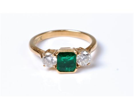 An 18ct emerald and diamond ring, the square emerald cut emerald, approx. 5.7 x 5.7mm, set to either side with a round brilli