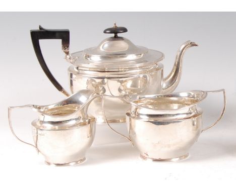 An Edwardian silver three-piece teaset, comprising teapot, twin handled sugar and cream, each of tapering oval form, the teap
