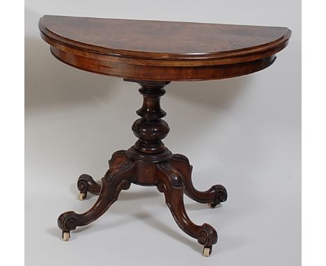 A Victorian figured walnut and satinwood inlaid card table, the D-shaped fold-over top revealing a baize lined playing surfac