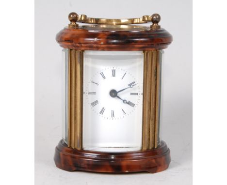 An early 20th century lacquered brass and enamelled minuet carriage clock, of barrel shape, having white enamel dial, visible