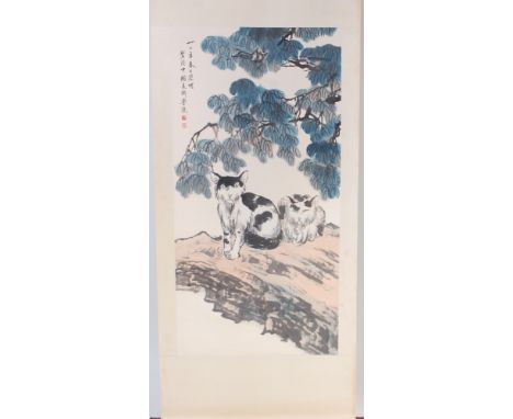 A Chinese scroll painting on paper laid on silk, depicting two cats under branches, with script and two seal marks upper left