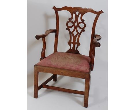 A George III fruitwood elbow chair, in the Chippendale style, having pierced vase splatback, swept arms, and drop-in seat