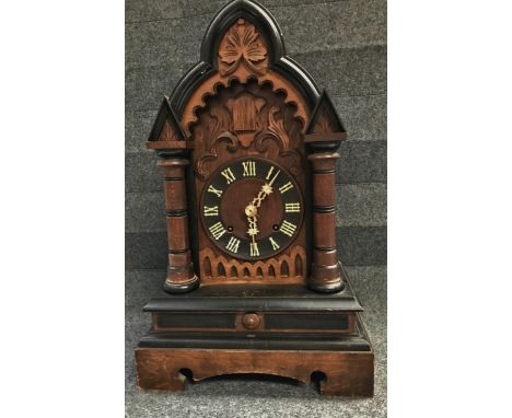 A 19th century pine cased Black Forest mantle clock with brass movement by J. Junghans, striking on a gong, the case with ebo