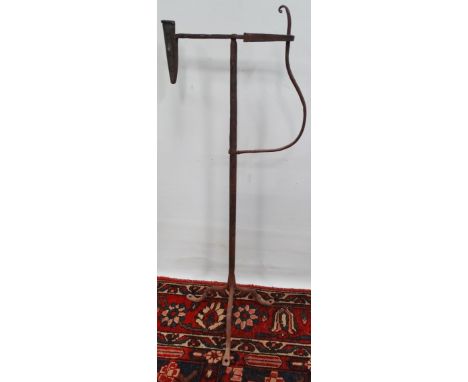 A wrought iron floor standing rush light holder upon tripod base, height 80cm. 