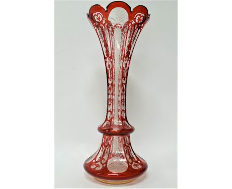 A Bohemian glass ruby overlay and white enamel and gilt painted flared vase, height 39.5cm (rim chips).