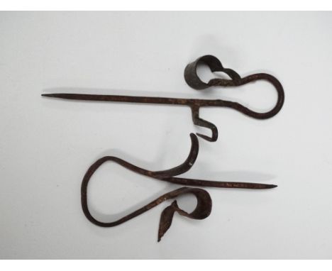 Two interesting wrought iron spike wall mounting rush or candle light holders, length of longest 18cm. 