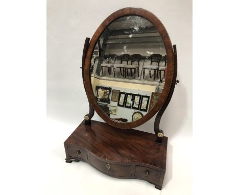 A George III mahogany crossbanded and boxwood and ebony inlaid dressing table swing mirror, the oval mirror on shaped support