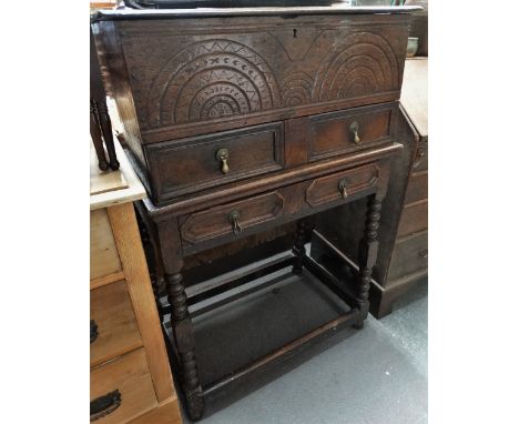 An 18th century oak bible box on stand, the hinged lid over an arcaded carved frieze with two dummy drawers, the base with a 