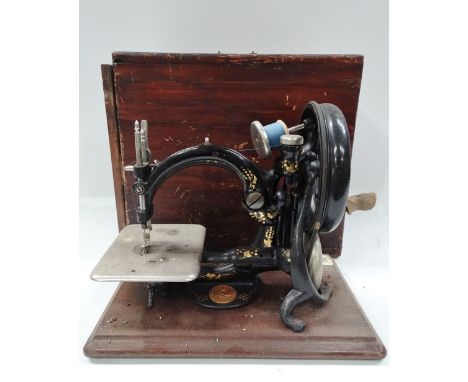 A small late 19th century manual sewing machine by Willcox &amp; Gibbs Sewing Machine Co. New York London Paris, with J.E.A. 