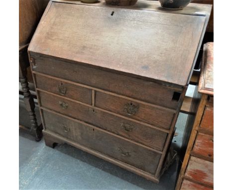 A mid 18th century small scale oak bureau with fitted interior, sliding well and four graduated drawers raised on bracket fee