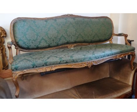 A 19th century gilt framed and carved sofa in mid 18th century style upholstered in green fabric.