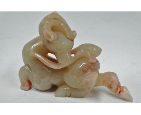 A Chinese celadon green and pink flecked jade carving of a deer with peach branch, length 9.5cm.