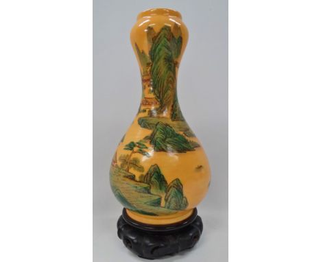 A Chinese gourd shaped yellow ground famille verte vase painted with a pagoda lake landscape, red printed seal mark to the ba