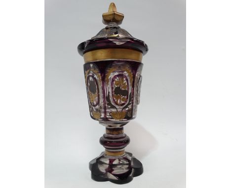 A bohemian amethyst overlay cut glass lidded pedestal vase with gilt and silvered enamel painted foliate decoration, height 3