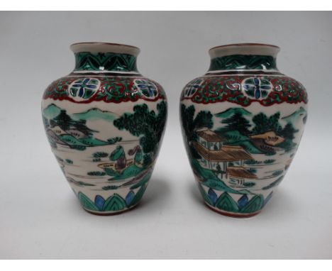 A pair of Chinese famille verte ovoid vases decorated with mountainous lake landscapes with buildings, with lappet and scroll