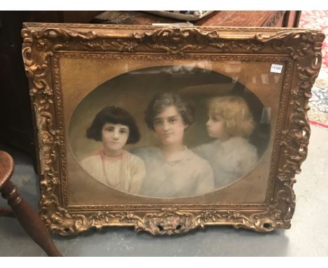 An early 20th century portrait group depicting a lady and two daughters, colour pastel on canvas within gilt gesso moulded fr