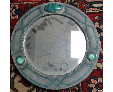 An English Arts &amp; Crafts pewter and enamel round wall mirror fitted with three Ruskin style cabochons, width 34cm. 