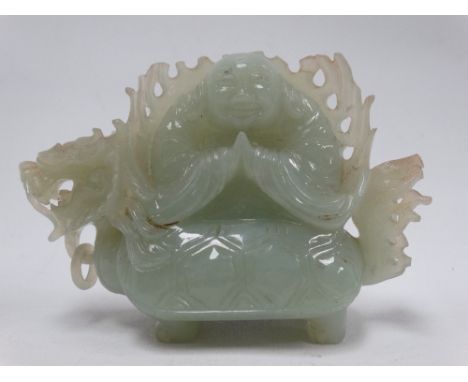 A Chinese celadon green jade carving depicting a portly immortal upon the back of a mythical beast with tortoiseshell, height