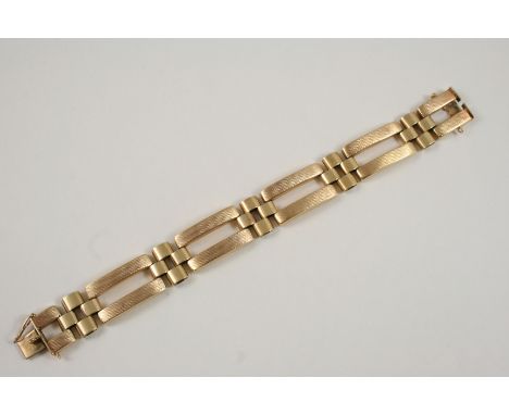 A 9CT. GOLD FANCY GATE LINK BRACELET with engine turned decoration to one side, and with concealed clasp, 18cm. long, 23 gram
