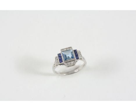 AN AQUAMARINE, SAPPHIRE AND DIAMOND CLUSTER RING the square-shaped aquamarine is set within a surround of calibre-cut sapphir