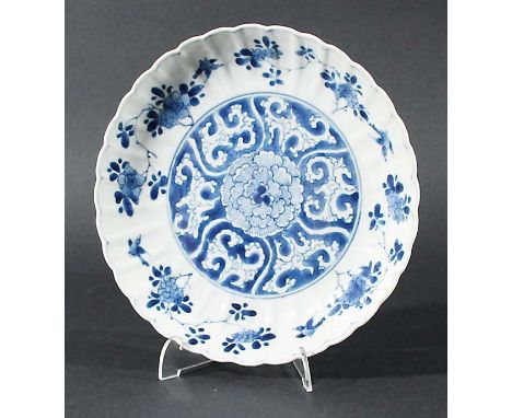 CHINESE SAUCER DISH, Kangxi, blue painted with a peony pattern inside a scalloped rim, blue five petal flowerhead inside a do