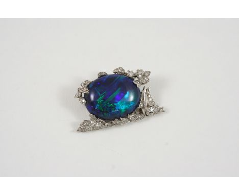 AN EARLY 20TH CENTURY BLACK OPAL AND DIAMOND BROOCH the oval-shaped solid black opal is set within a surround millegrain set 
