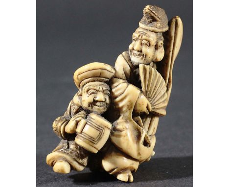 JAPANESE NETSUKE OF TWO IMMORTALS, one holding a fan the other a mallet, height 7cm