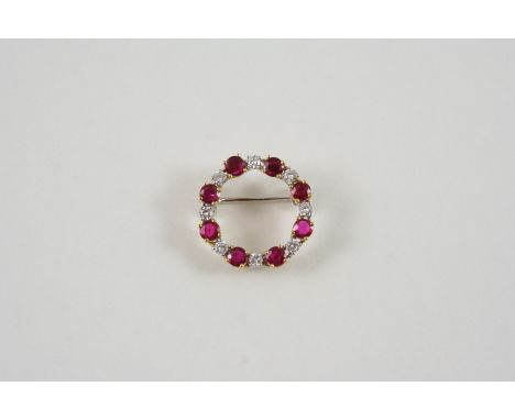 A RUBY AND DIAMOND CIRCLE BROOCH alternately set with circular-cut rubies and diamonds, in 18ct. gold, 2.1cm. dia.