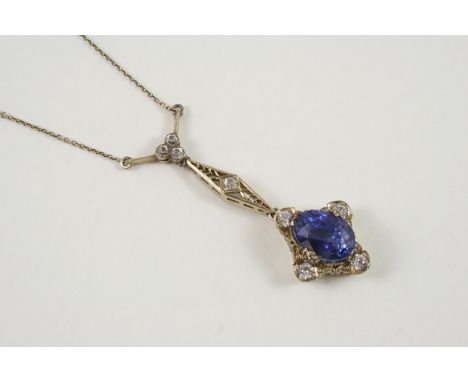 A SAPPHIRE PENDANT the oval-shaped sapphire is set within an openwork surround mounted with circular white stones, 5cm. long.