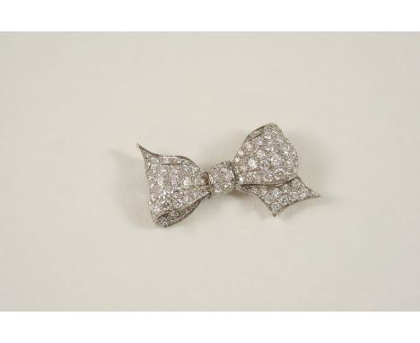 A DIAMOND BOW BROOCH millegrain set with graduated circular-cut diamonds, 4.5cm. wide.