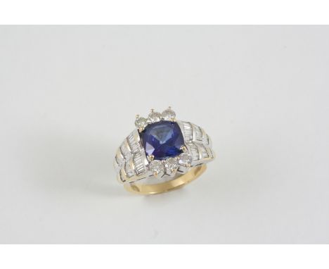 A SYNTHETIC SAPPHIRE AND DIAMOND CLUSTER RING the rounded square-shaped synthetic sapphire is set within a surround of circul